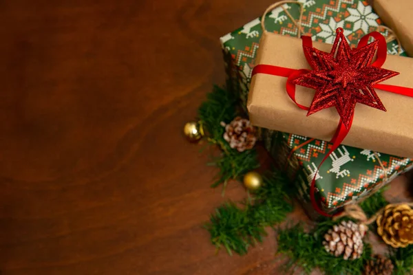 Noel süsleriyle çevrili Noel hediyeleri. Noel ağacında kar taneleri ve yapraklar