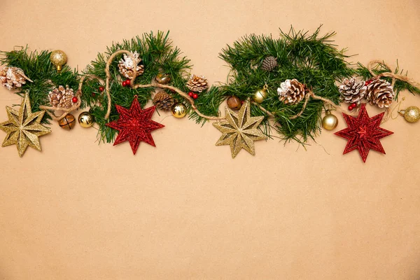 Noel süsleri. Kırmızı yıldızlı, altın küreli ve kar taneli bir Noel ağacının yaprakları