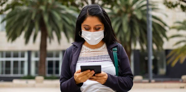 Business woman with mask, she is reading e book