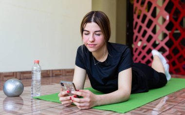 Genç ve formda bir kadın evde spor yapıyor.