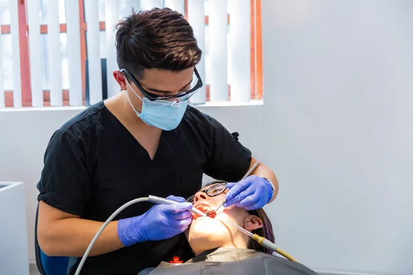 Series of photos at a dentist\'s office. A young brunette woman sitting in a dentist\'s chair. A dentist giving her a lip injection