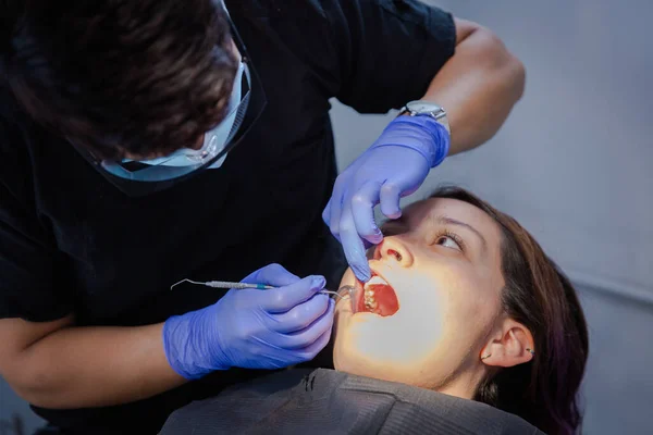 Series of photos at a dentist\'s office. A young brunette woman sitting in a dentist\'s chair. A dentist giving her a lip injection