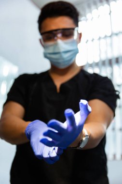 Doktor mavi lateks eldiven giyiyor. Ön görünüm