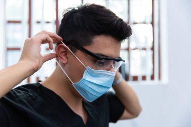 Maskeli ve gözlüklü bir doktorun yakın çekimi. Ön görünüm