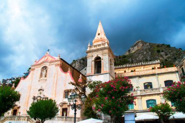 Sicilya adasındaki Taormina kentinin mimari ve kiliseleri. Eski kasabanın yeri denizden yaklaşık 300 metre yukarıdayken, Sarazen şatosu tarafından taçlandırılan çok sarp ve neredeyse izole edilmiş bir kaya.