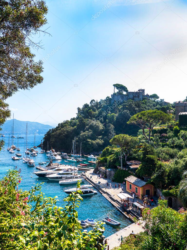 Portofino  is an Italian fishing village and vacation resort famous for its picturesque harbour and historical association with celebrity and artistic visitors.View of Castello Brown a house,garden and  museum high above the harbour of Portofino. 