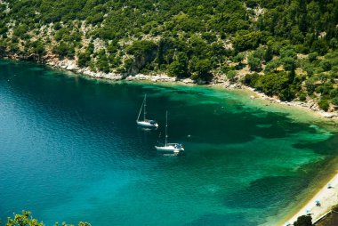 Sami yakınlarındaki Kephalonia adasındaki Antisamos Körfezi 'nde her şeyden uzakta dinlenme günü. Serin rüzgarların altında, yeşil tepelerle çevrili yeşil Akdeniz 'in sıcacık turkuvaz rengi rüzgarları altında tembel günleri canlandırır.