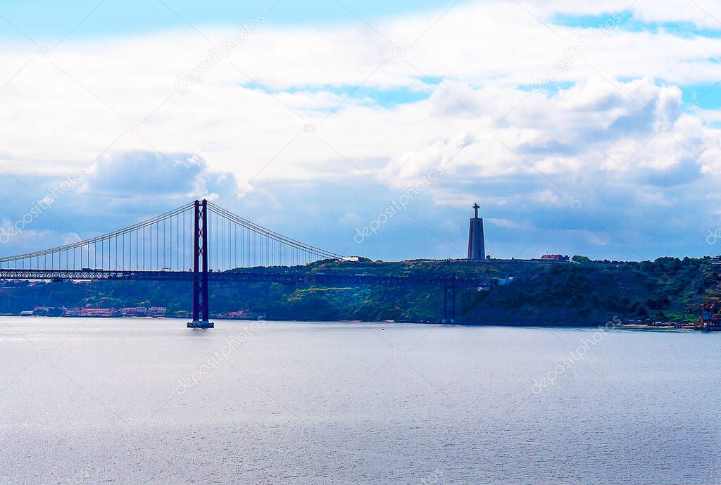 Vasco da Gama Bridge over the River Tagus and the statue of Christ in the opposite bank. The Sanctuary of Christ the King is a monument shrine dedicated to the Sacred Heart of Jesus Christ, inspired by the Christ the Redeemer statue of Rio de Janeiro