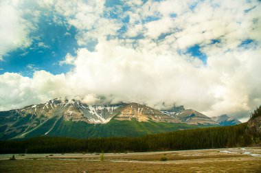 Kanada 'daki Jasper Ulusal Parkı' ndaki Kanada Rocky Dağları Calgary 'nin 180 km batısındaki Trans-Canada Otoyolu' ndan görülmektedir. Otoyol, Temple Dağı, Whyte Dağı ve Niblock Dağı da dahil olmak üzere karla kaplı dağların manzarasıyla geçer. . 