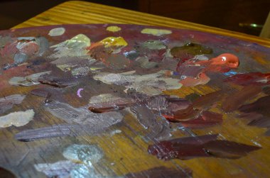 Karışık ve karıştırılmamış akrilik renklere sahip bir ressam paletinin stok fotoğrafı