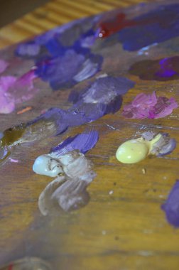 Karışık ve karıştırılmamış akrilik renklere sahip bir ressam paletinin stok fotoğrafı