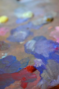 Karışık ve karıştırılmamış akrilik renklere sahip bir ressam paletinin stok fotoğrafı