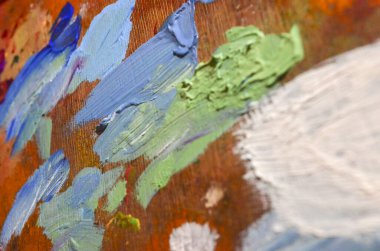 Karışık ve karıştırılmamış akrilik renklere sahip bir ressam paletinin stok fotoğrafı