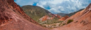 Arjantin, Jujuy 'daki Purmamarca köyündeki renkli tepelerin ve dağların panoramik fotoğrafı. Peyzaj