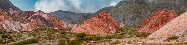 Arjantin, Jujuy 'daki Purmamarca köyündeki renkli tepelerin ve dağların panoramik fotoğrafı. Peyzaj