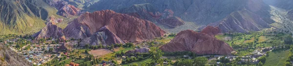 Arjantin, Jujuy 'daki Purmamarca köyündeki renkli tepelerin ve dağların panoramik fotoğrafı. Peyzaj