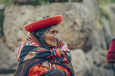 Sacsayhuaman İnka arkeolojik sahasında ve Peru, Cusco dışındaki antik kalede geleneksel ve renkli giyinmiş Perulu yaşlı kadın. 17 Ocak. 2014