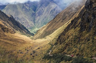 Inca 'nın Peru' daki antik medeniyetinden Machu Picchu arkeoloji sahasına giden tanınmayan sırt çantalı gezginler, uzak bir hava manzarasından inka patikalarına doğru yürüyorlar. Güney Amerika