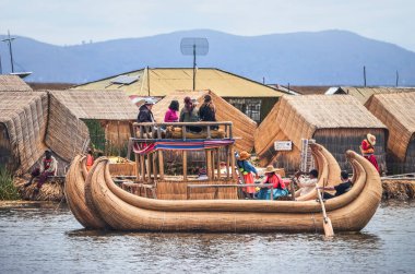 Uros Adası, Titicaca Gölü, 27 Ocak 2014. Uros Adaları 'nda yüzen sazlıktan yapılmış bir teknede yaşayan turistler ve yerliler. Puno, Peru