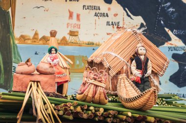 Titicaca Gölü, Puno, Peru 'daki Uros Adaları' na demirlemiş yüzen kamışlardan yapılmış ev ve teknelerin yerel hatıra eşyası.