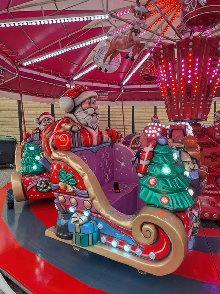 Noel Baba lunaparktaki atlıkarıncaya biniyor.