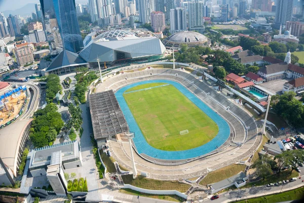 Modern bir Asya Metropolü şehrinde yüksek binalarla çevrili Geniş Açı Stadyum ve Pist Manzarası
