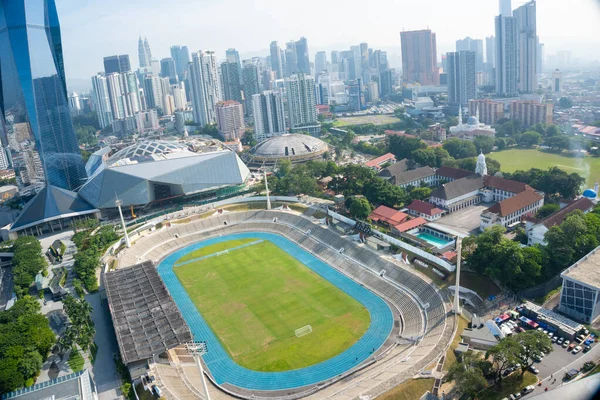Modern bir Asya Metropolü şehrinde yüksek binalarla çevrili Geniş Açı Stadyum ve Pist Manzarası