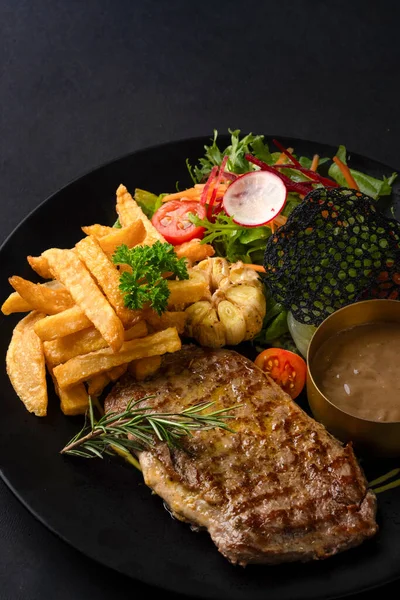 Patates ve sebzeli kızarmış biftek.