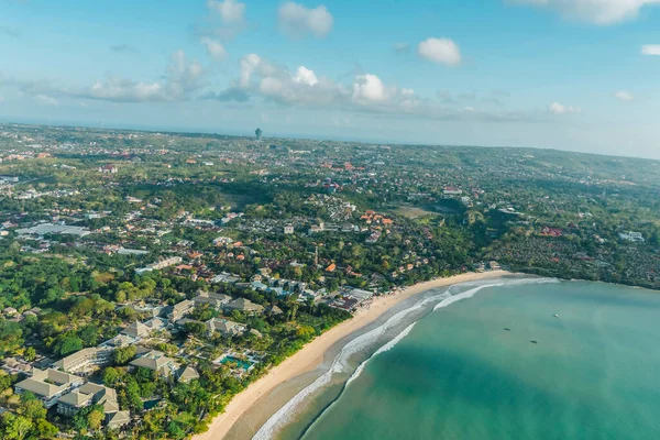 Hindistan cevizi palmiyeleri ve mavi suyu olan güzel tropik plajın havadan görünüşü.