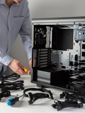 Yeni bir bilgisayarın montajı, erkek ana yeni bir sistem ünitesi kuruyor, açık kasa ve kablolar
