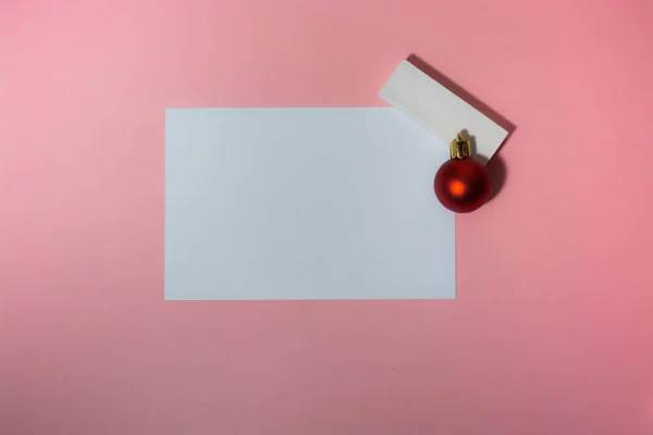 Świąteczna kartka na różowym tle z kulkami choinkowymi — Zdjęcie stockowe