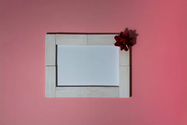 Біло-блокова листівка, прикрашена бантом на рожевому фоні — стокове фото