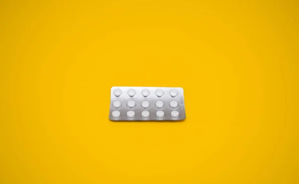 Lékařské kapsle, pilulky na žlutém pozadí. — Stock fotografie