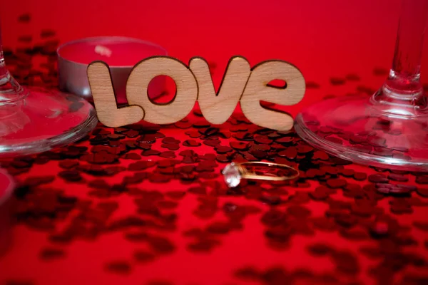 Обручальное кольцо на сердечных конфетах рядом с надписью любви — стоковое фото