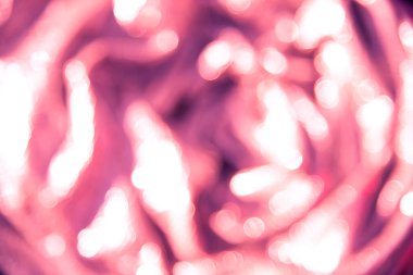 Pembe ve eflatun arkaplandaki bulanık parlayan ışıkların soyut arkaplanı