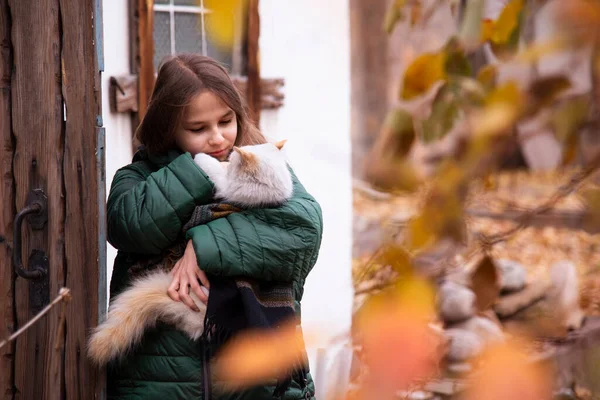 Flicka Med Långt Hår Håller Vit Katt Mot Bakgrunden Trädörr — Stockfoto