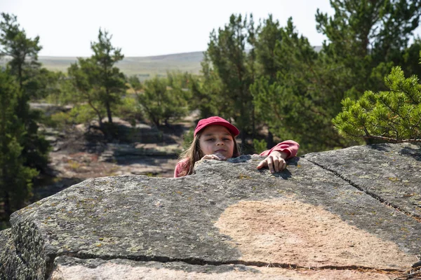 Wajah Seorang Gadis Dengan Topi Merah Memanjat Batu Dengan Latar — Stok Foto