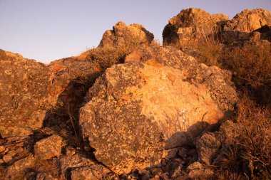 Güneş batarken yakın planda altın gibi kayalar. Doğal arka plan. Doğal güzellik kavramı