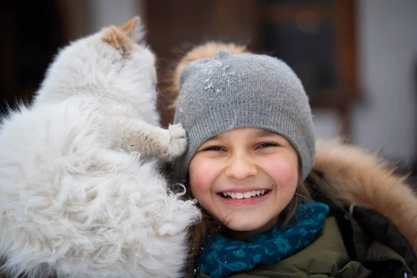 Lächelndes Mädchen Mit Wintermütze Und Weißer Katze Auf Der Schulter — Stockfoto