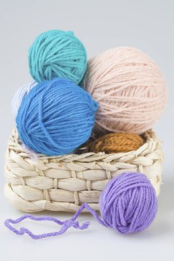 Hasır bir sepette el örgüsü örmek için iplik yumakları