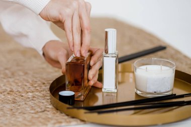 Aroma bambu çubukları şişede, kokulu sıvı ve mumlar ahşap tepside yakın planda duruyor..