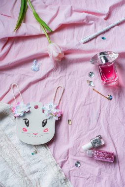 Mutlu Paskalya tebrik kartları. Çiçek, sim, parfüm ve pembe arka planda beyaz tavşan kulağı. Tatil kavramı, doğum günü, 8 Mart. Düz yatıyordu. Şirin, küçük, kadınsı şeyler, üst manzara. Kızsal Şeyler.