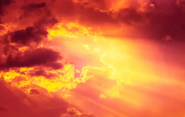 red overcast sky with yellow and orange sun beam light and dim cloudy