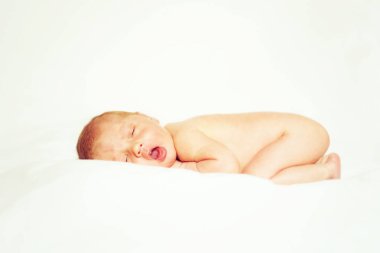 Beyaz arka planda uyuyan yeni doğmuş bir kız.