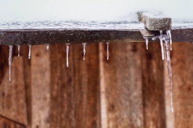Evin çatısında buz saçakları var.