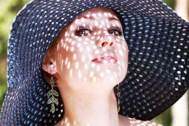 Şapkalı güzel beyaz bir kadının yakın plan portresi.