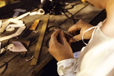 Eski moda yöntemlerle deriden el işi yapıyorlar.