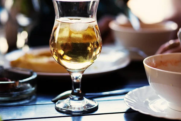 Buzlu ve arta kalan yiyeceklerle dolu büyük bir bardak beyaz şarapla sakin bir hayat.