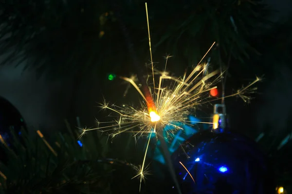 Iluminado Sparkler Fundo Uma Árvore Natal Com Brinquedos Dia Natal — Fotografia de Stock