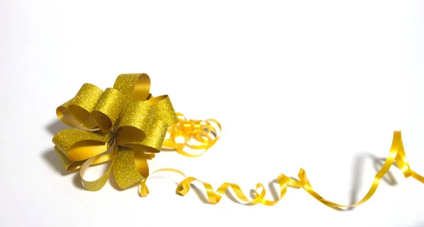 Goldene Schleife mit gelbem Band auf weißem Hintergrund. Urlaub, Glückwunsch. — Stockfoto